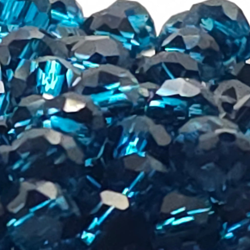 A close-up of a dark gray circular base covered with faceted blue rhinestones, photographed against a plain white background.