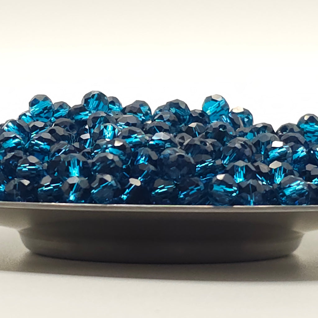 A close-up of a dark gray circular base covered with faceted blue rhinestones, photographed against a plain white background.