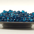 A close-up of a dark gray circular base covered with faceted blue rhinestones, photographed against a plain white background.