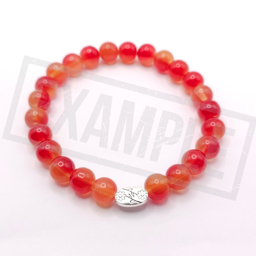 A beaded stretch bracelet made of round translucent light orange beads with a small silver oval charm, shown on a white background.