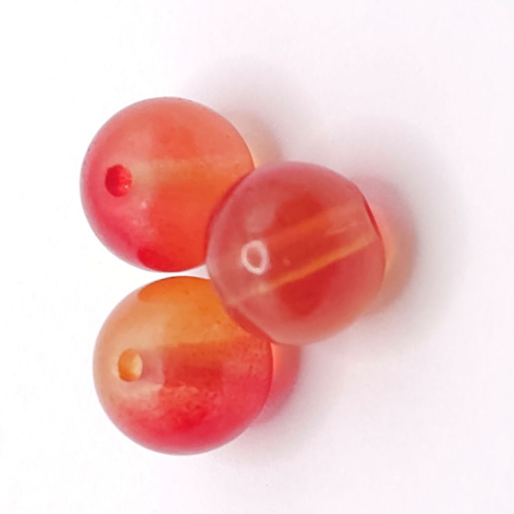 Three round translucent Bright orange beads with a natural stone appearance, each featuring a central hole, displayed on a clean white background.