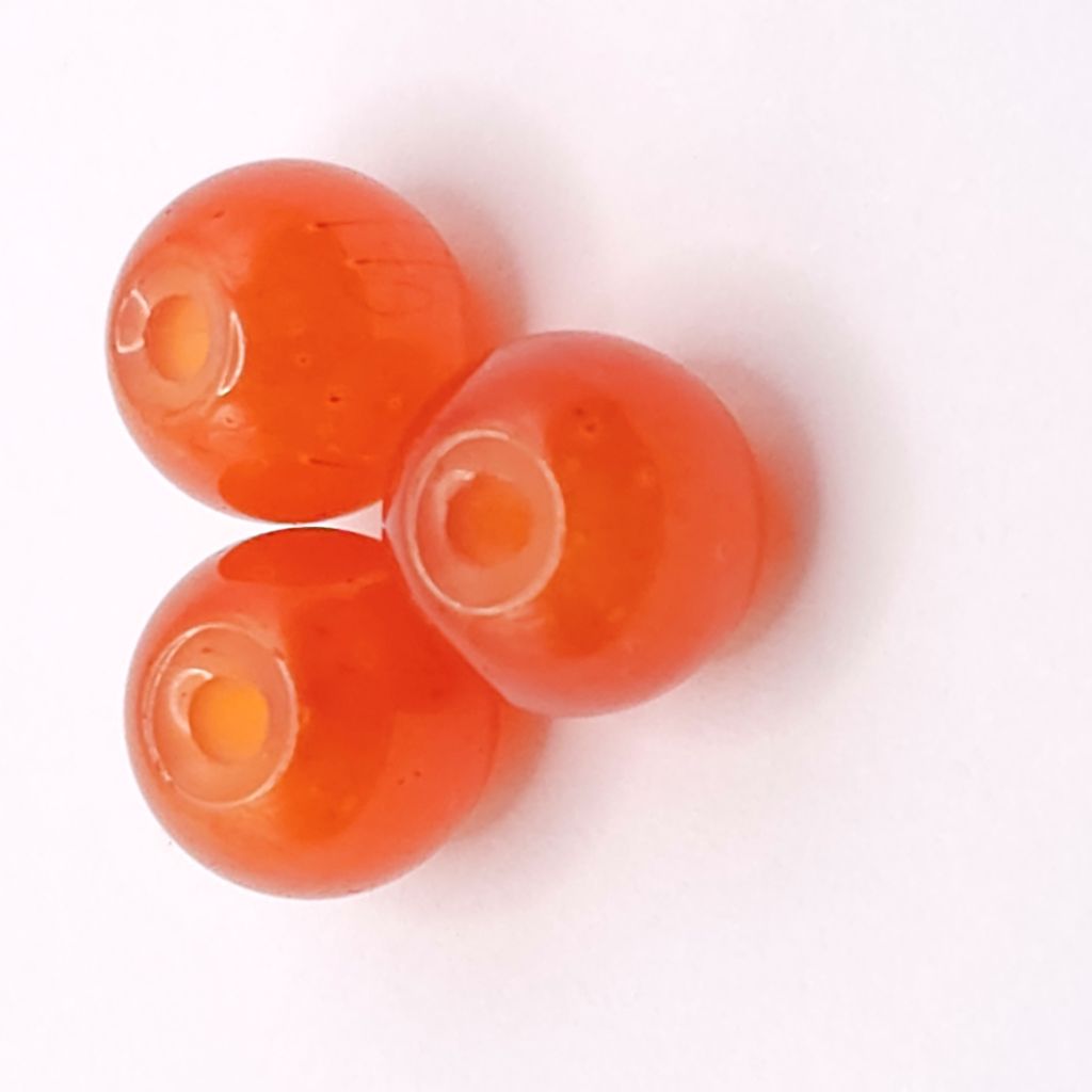 Three round translucent dark orange beads with central holes, arranged on a plain white background.