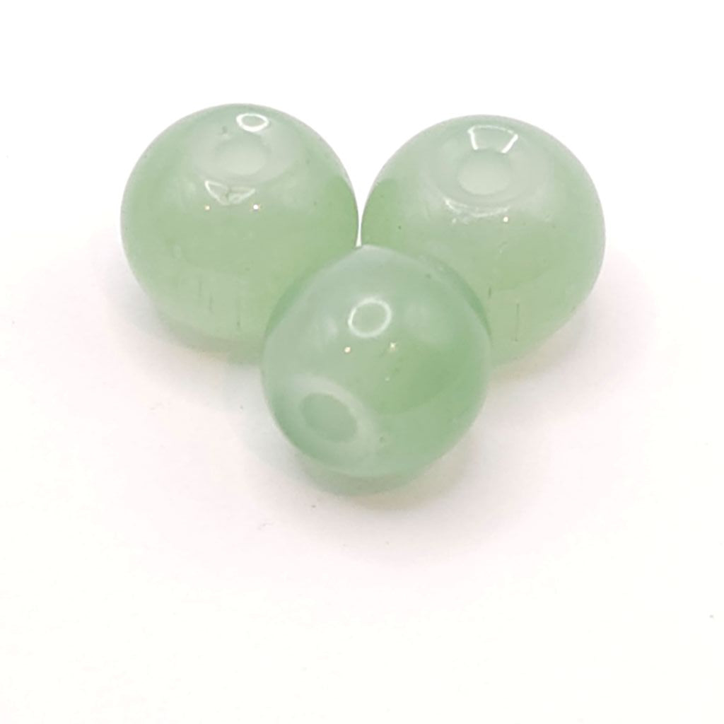 Three emerald green translucent round beads with central holes, arranged on a plain white background.