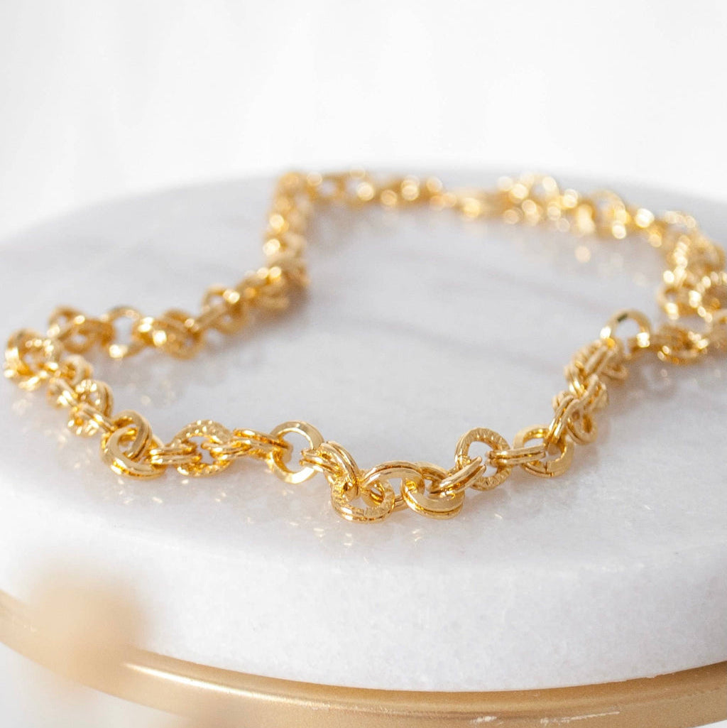 Gold chain necklace on a marble surface