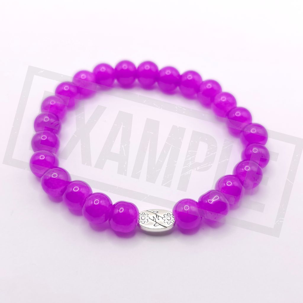 A light purple beaded stretch bracelet with a small silver oval charm in the center, displayed on a white background.