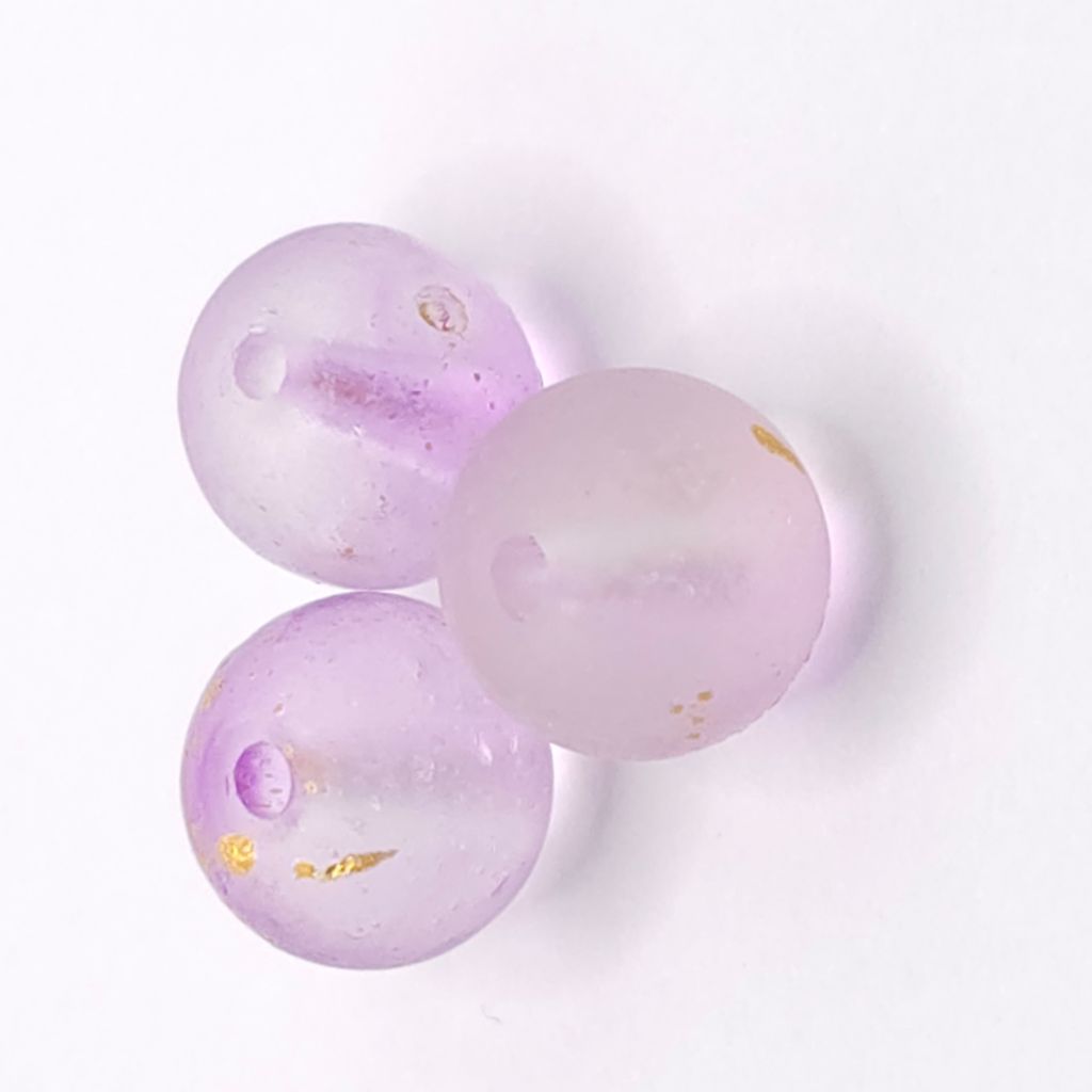 Three round light purple glass beads with small gold foil flakes, displayed on a clean white background.