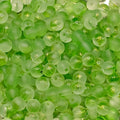 A close-up pile of small, round, translucent light green beads with a frosted finish.