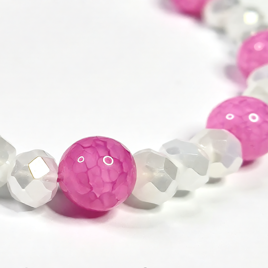 Bracelet with pink and white beads on a white background 