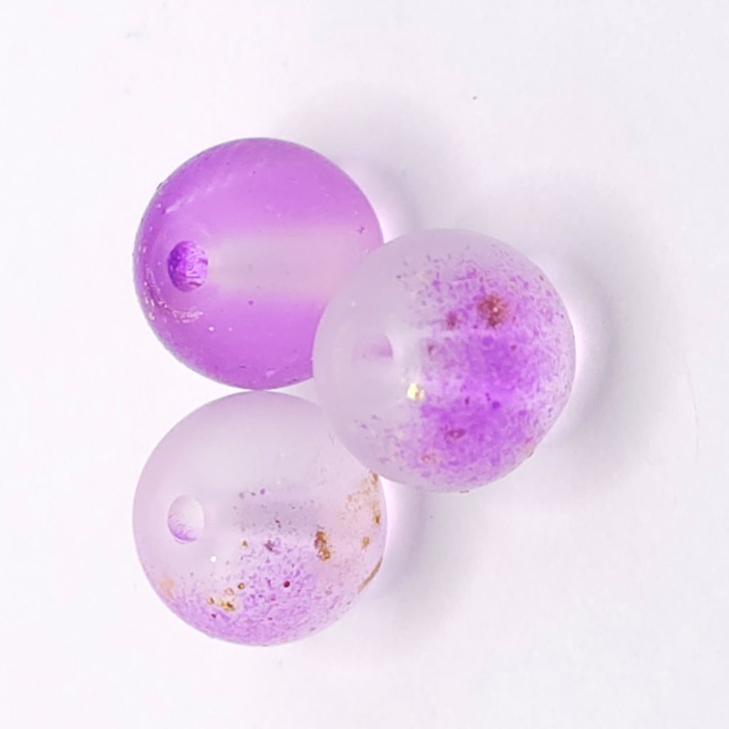 Three round translucent medium purple beads with embedded glitter, displayed on a clean white background.