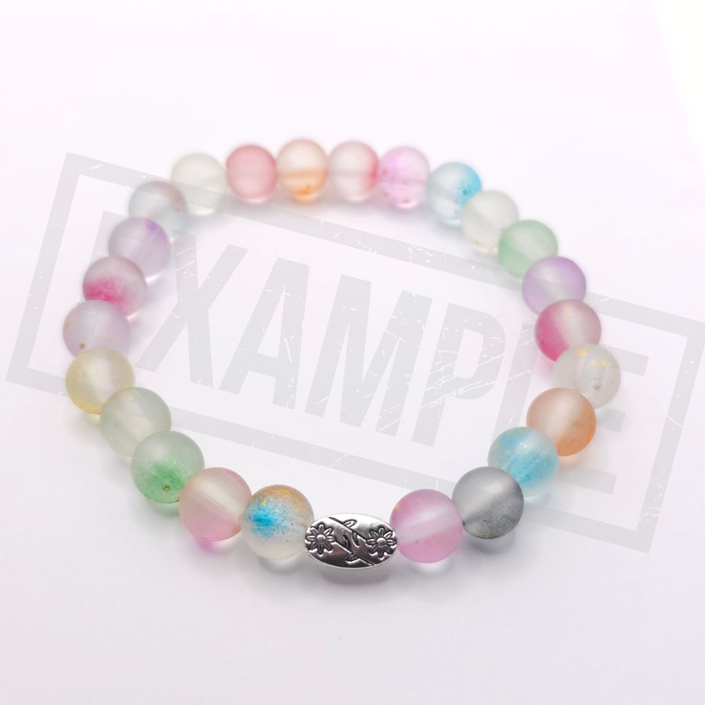 A beaded stretch bracelet featuring translucent pastel gemstone beads in pink, green, blue, purple, and orange, with a central silver-toned metal charm, displayed on a white background.