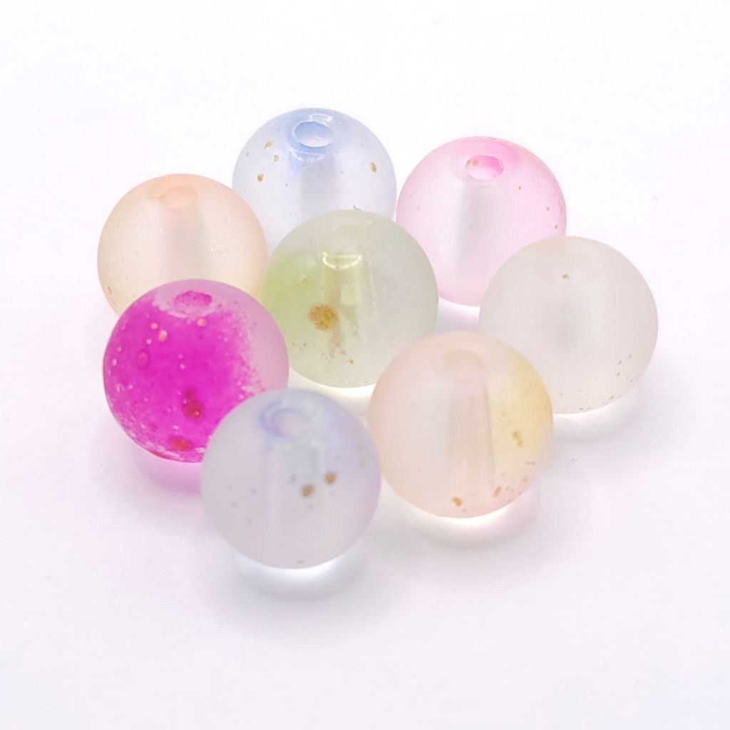 A group of eight translucent round beads in pastel shades of pink, purple, blue, green, and cream, some with tiny gold flecks, arranged on a white background.