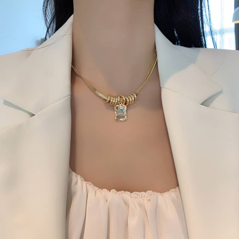 Model wearing a gold necklace with a pendant