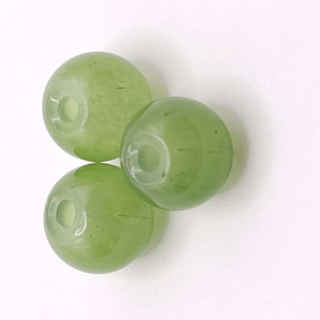 Three round translucent olive green beads with a central hole, arranged on a plain white background.