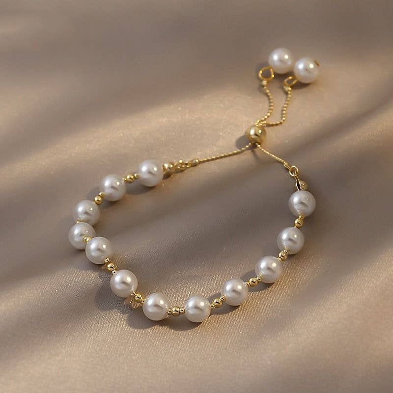 Pearl bracelet with gold accents on a beige fabric background