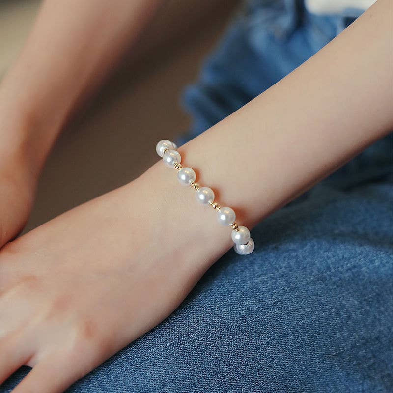 Pearl bracelet on a person's wrist with a blurred background