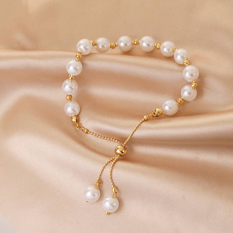 Pearl bracelet with gold accents on a beige fabric background