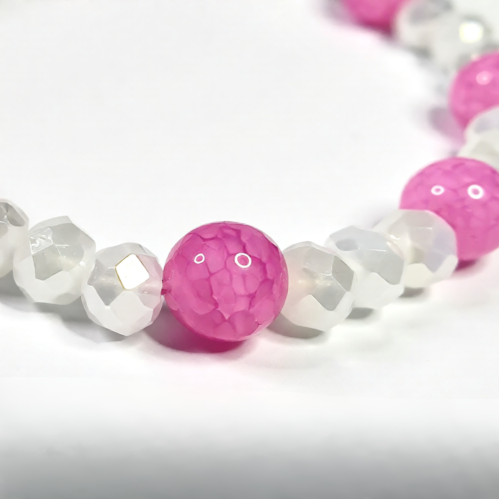 bracelet with pink and white beads on a light grey background