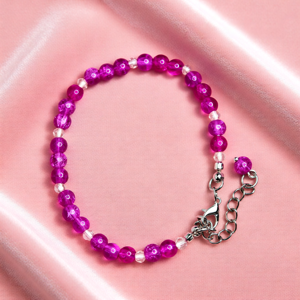 Pink beaded bracelet with a silver clasp on a pink background