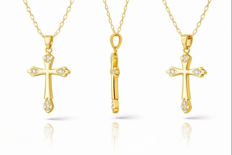 Three gold cross pendants on gold chains against a white background