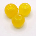 Three translucent yellow round beads with a hollow center, arranged on a plain white background.