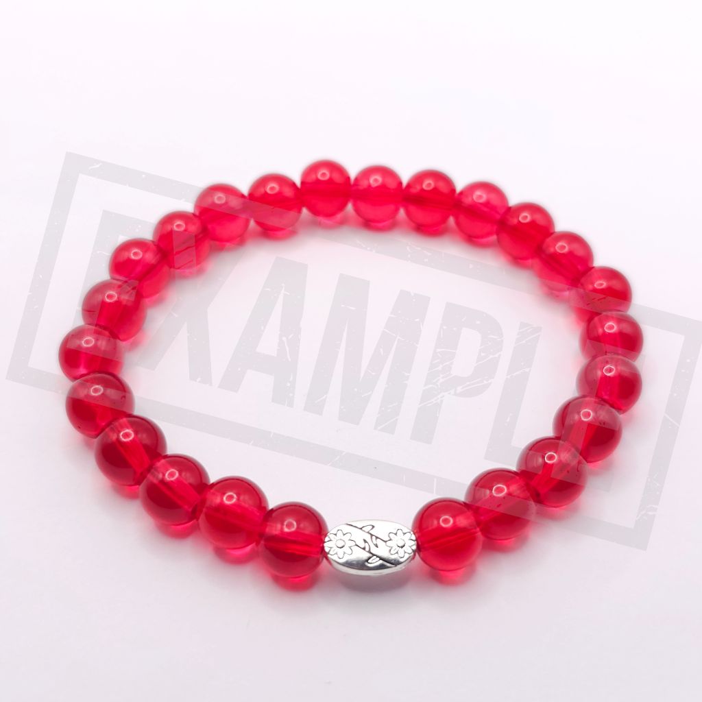 A red translucent beaded bracelet with a silver-toned floral charm, displayed on a white background.