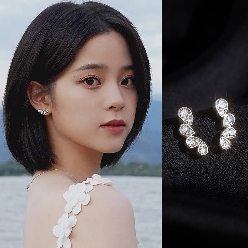Woman wearing earrings with a close-up of the earrings on a dark background